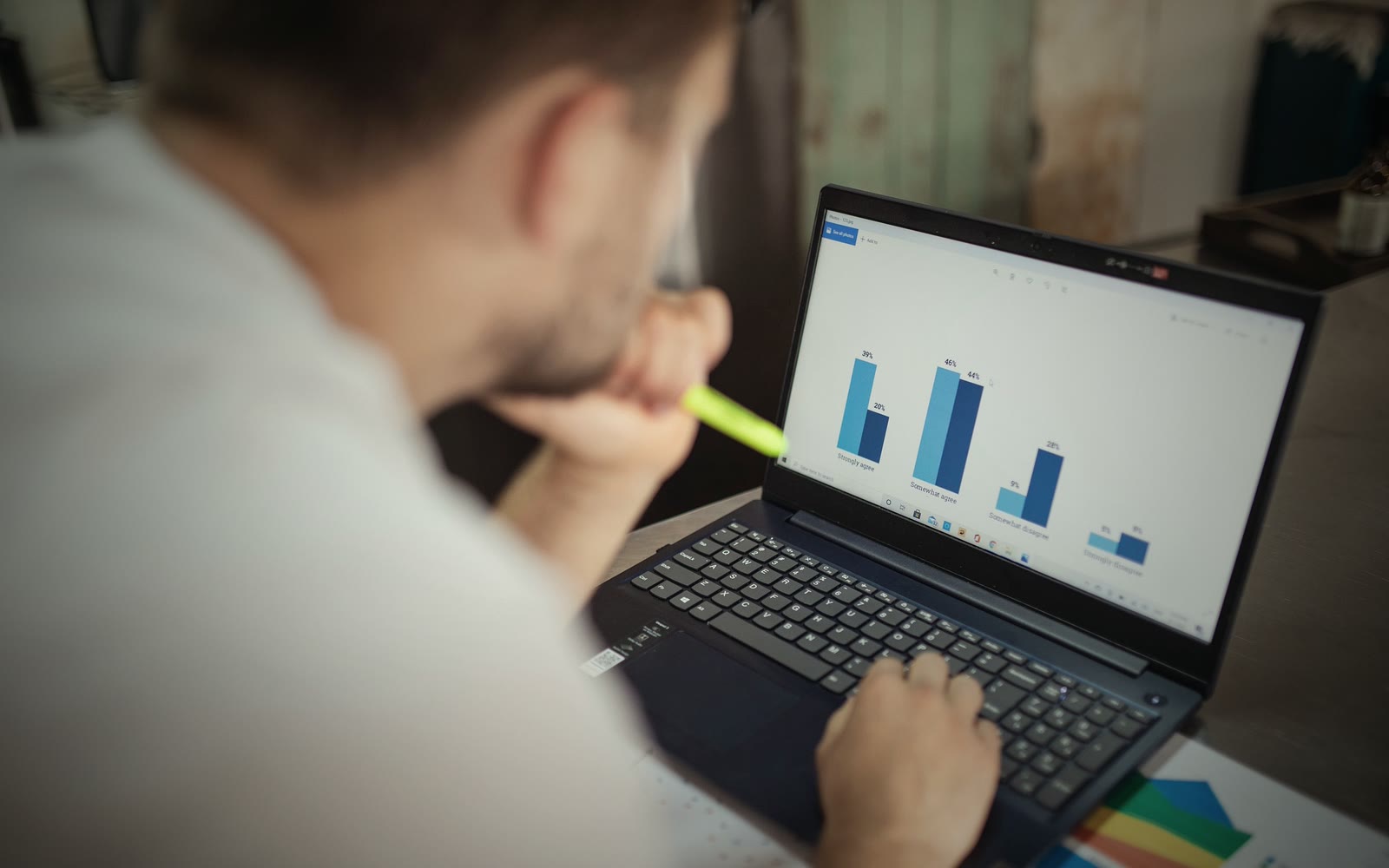 Someone studying a bar chart on a laptop screen, seen over their shoulder